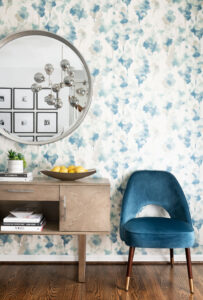 Console and chair with blue floral wallpaper in the background