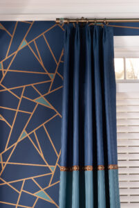 Geometric blue and gold wallpaper with navy drapes