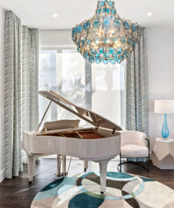 White piano under blue glass chandelier 